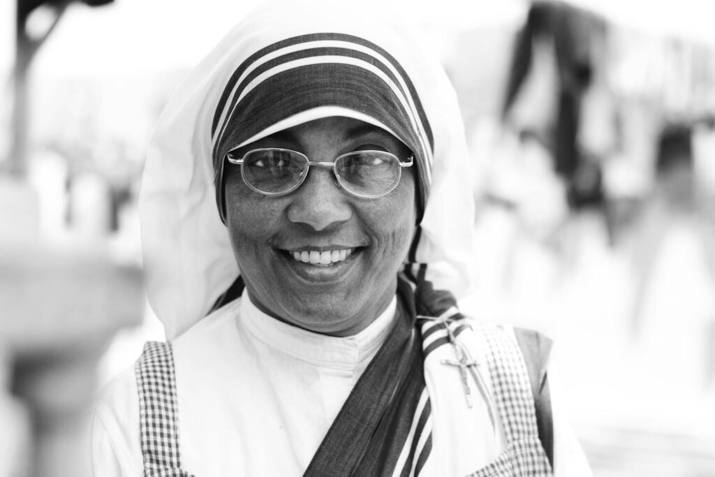 Black and white portrait of a smiling nun with veil outdoors in San Felipe, Venezuela.